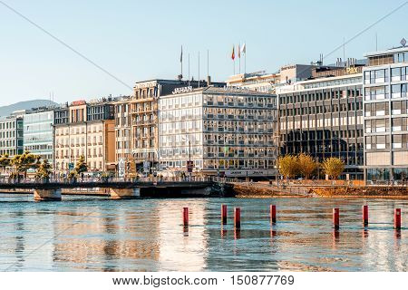 Geneva, Switzerland - June 23, 2016: Riverside buildings with offices of famous brands in the center of Geneva city. Geneva is a financial center and worldwide center for diplomacy in Europe