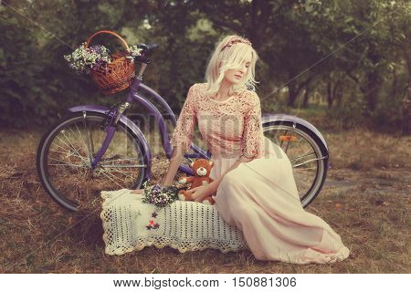 Sad girl in a park with a children's toy near the bike.