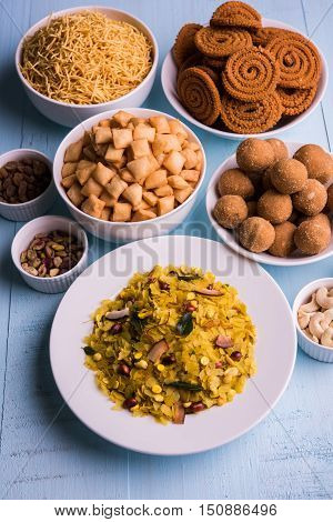 homemade tasty Diwali food or Diwali snacks or Diwali sweets like rava laddu, chakli, sev, shankar pale and chivda or chiwada with dry fruits in white bowls, favourite indian diwali recipe