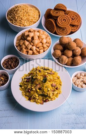 homemade tasty Diwali food or Diwali snacks or Diwali sweets like rava laddu, chakli, sev, shankar pale and chivda or chiwada with dry fruits in white bowls, favourite indian diwali recipe