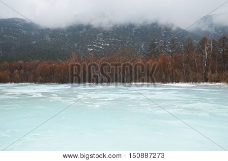 Icebound river on a cloudy spring day. Irkutsk Region, Russia