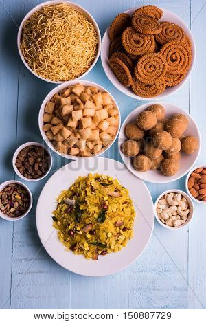homemade tasty Diwali food or Diwali snacks or Diwali sweets like rava laddu, chakli, sev, shankar pale and chivda or chiwada with dry fruits in white bowls, favourite indian diwali recipe