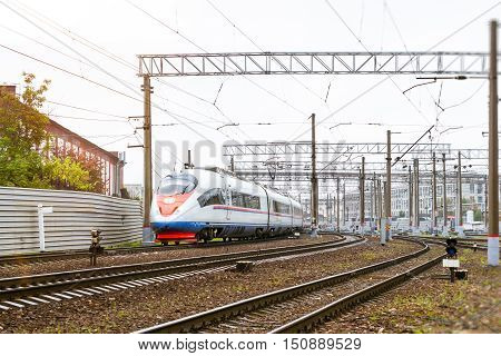 Modern hybrid electric locomotive Sapsan pulling high-speed train with railcars rzd on rails. Technical railway depot. Transport route St. Petersburg - Moscow Saint-Petersburg railway station Russia