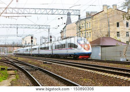 Modern hybrid electric locomotive Sapsan pulling high-speed train with railcars rzd on rails. Technical railway depot. Transport route St. Petersburg - Moscow Saint-Petersburg railway station Russia