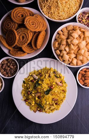 homemade tasty Diwali food or Diwali snacks or Diwali sweets like rava laddu, chakli, sev, shankar pale and chivda or chiwada with dry fruits in white bowls, favourite indian diwali recipe