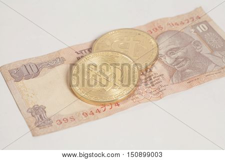 Golden bitcoin coins on Indian Ten Rupee on white background