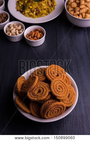 homemade tasty Diwali food or Diwali snacks or Diwali sweets like rava laddu, chakli, sev, shankar pale and chivda or chiwada with dry fruits in white bowls, favourite indian diwali recipe