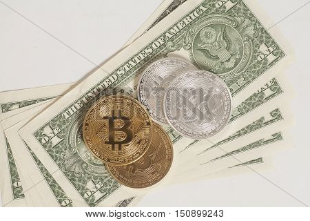 Golden and silver bitcoin coins and one dollar banknotes on white background