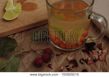 sea buckthorn tea in a transparent mug and a rose hip lime. useful warming winter drink.