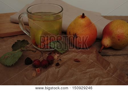 sea buckthorn tea in a transparent mug and a rose hip lime and pear. useful warming winter drink.