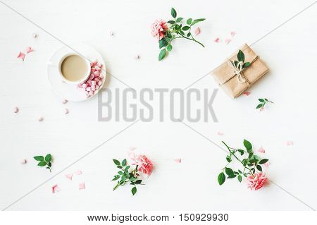 Workspace. Gift cup of coffee and rose flowers. Flat lay top view