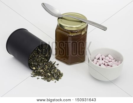 Dried herbs making a green herb tulse with chestnut honey and Vitamin B12 tablets