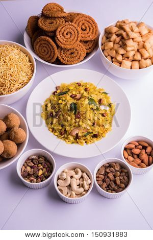 home made tasty Diwali food or Diwali snacks or Diwali sweets like rava laddu, chakli, sev,shankar pale and chivda or chiwada with dry fruits in white bowls, favourite indian diwali recipe