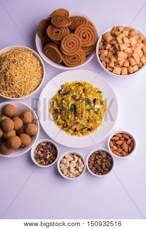 home made tasty Diwali food or Diwali snacks or Diwali sweets like rava laddu, chakli, sev,shankar pale and chivda or chiwada with dry fruits in white bowls, favourite indian diwali recipe