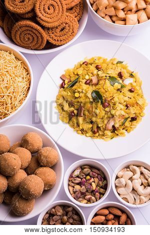 home made tasty Diwali food or Diwali snacks or Diwali sweets like rava laddu, chakli, sev,shankar pale and chivda or chiwada with dry fruits in white bowls, favourite indian diwali recipe