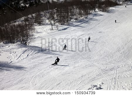 Skiers And Snowboarders On Ski Slope At Sun Winter Day