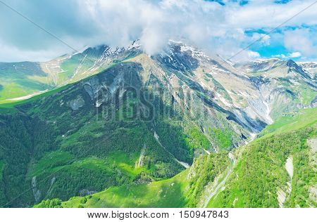 The breathtaking view on the peaks of Greater Caucasus in clouds from Gudauri (Cross) Pass Georgia.