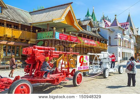 MOSCOW RUSSIA - MAY 10 2015: The kids play and pose on colorful howitzers exhibited in Izmailovsky Kremlin to the Victory Day on May 10 in Moscow.