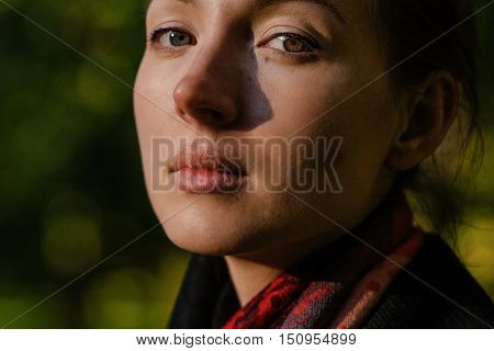pretty girl with freckles and heterochromia looking at camera