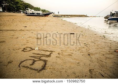Bali Indonesia written in sand at Sanur Beach sunset