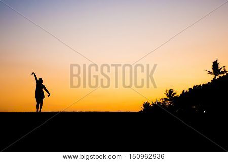 Bali in Indonesia dancing girl silhouette at Sanur Beach sunset