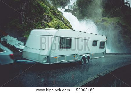 Travel Trailer Vacation Trip. Caravaning on the Road. Speeding Car with Travel Trailer on the Norway Scenic Road.