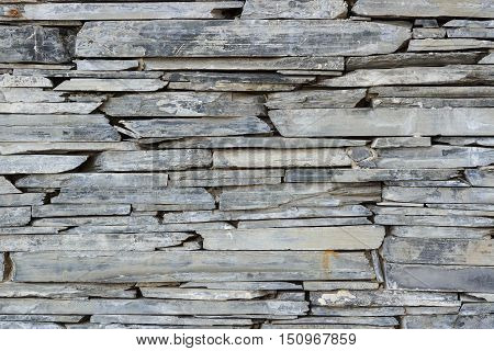 Layer of stone plate arranged as a wall / Stone wall background