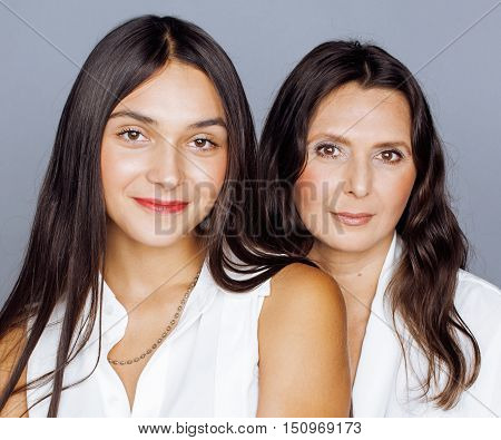 cute pretty teen daughter with mature mother hugging, fashion style brunette makeup close up, real happy family