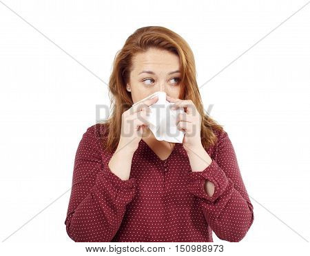 girl blows her nose into a tissue. portrait of a woman with tissue in hands. looking away. the concept of treatment for allergies or the common cold. isolated on white background