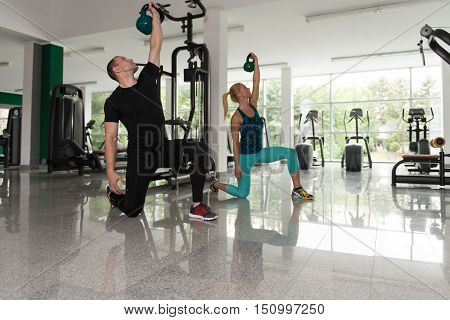 Healthy Young Couple Doing Exercise With Kettle Bell