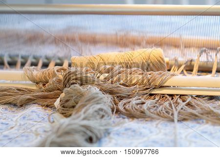 Preparing a loom before starting to make carpets. Warm light.