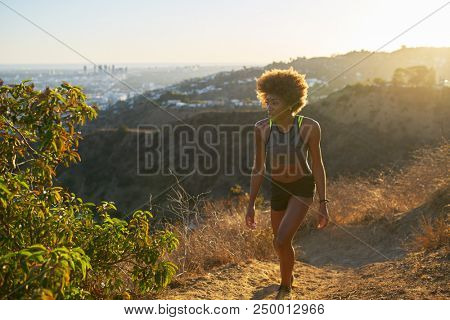 fit african american woman hiking up runyon canyon at sunset