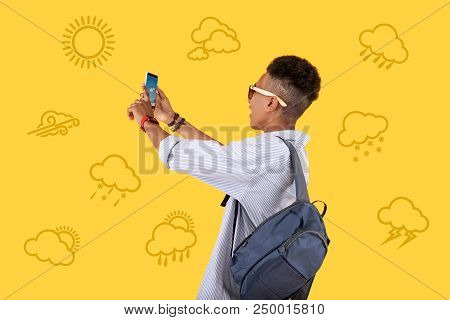 Sunny Day. Emotional Teenager Standing With A Modern Smartphone In His Hands And Smiling While Enjoy