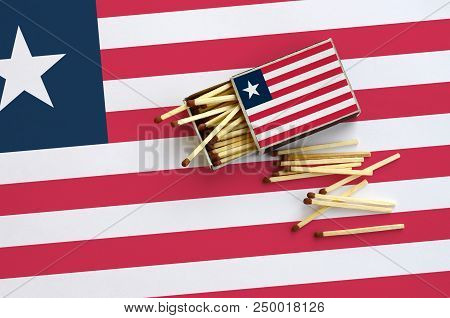 Liberia Flag  Is Shown On An Open Matchbox, From Which Several Matches Fall And Lies On A Large Flag