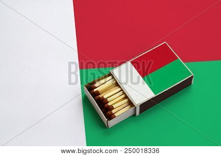 Madagascar Flag  Is Shown In An Open Matchbox, Which Is Filled With Matches And Lies On A Large Flag