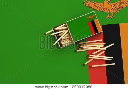 Zambia Flag  Is Shown On An Open Matchbox, From Which Several Matches Fall And Lies On A Large Flag.