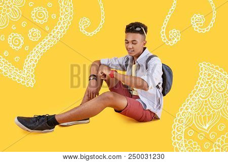 Checking Time. Cheerful Student Waiting For His Bus And Smiling While Looking At The Watch