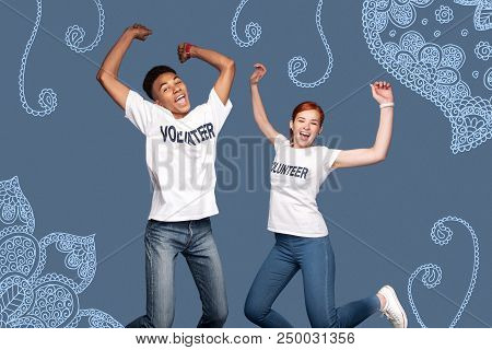 Jumping Volunteers. Happy Young Volunteers Jumping While Celebrating The Beginning Of A New Useful P
