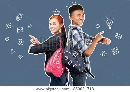 Confident Friends. Emotional Positive Students Standing Back To Back And Smiling While Using Modern 