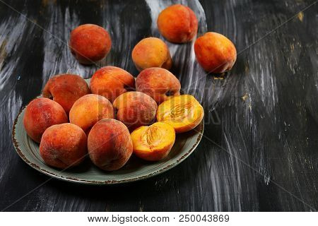 A Group Of Ripe Peaches On A Plate. Dark Background. Fresh Peach Concept. Flat Lay. Copy Text.