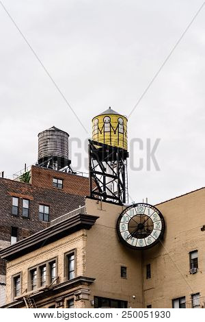 New York City, Usa - June 20, 2018: Low Angle View Of Water Towers And Clock On Top Of Old Buildings