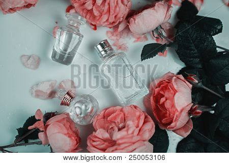 Perfumed Rose Water In Glass Bottles On White