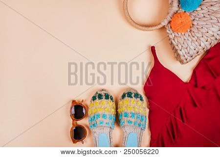 Summer Fashion Flatlay With Brown Sunglasses, Trendy Straw Bag With Pompoms, Red Swimsuit With Frill