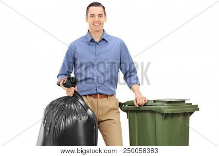 Young man with a trash bag and a garbage can isolated on white background