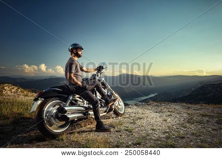 Biker leaning on a motorcycle enjoying the view