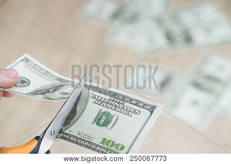 Scissors Cut Dollars In The Hands Business Concept.