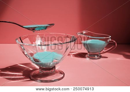 Blue Liquid In A Spoon Above A Glass Tray In The Background Of A Cherry