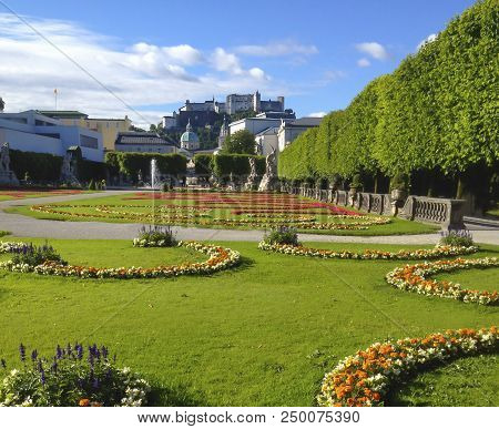Beautiful Summer Day View Of Mirabell Gardens With Festung Hohensalzburg Castle In The Background, S
