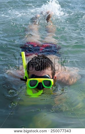 Young Man Wearing A Mask Underwater Tube Dives Into The