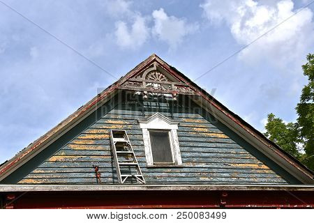 A Step Ladder On Top Of A Porch Is Dangerously Used To Reach The Trim And Facia.